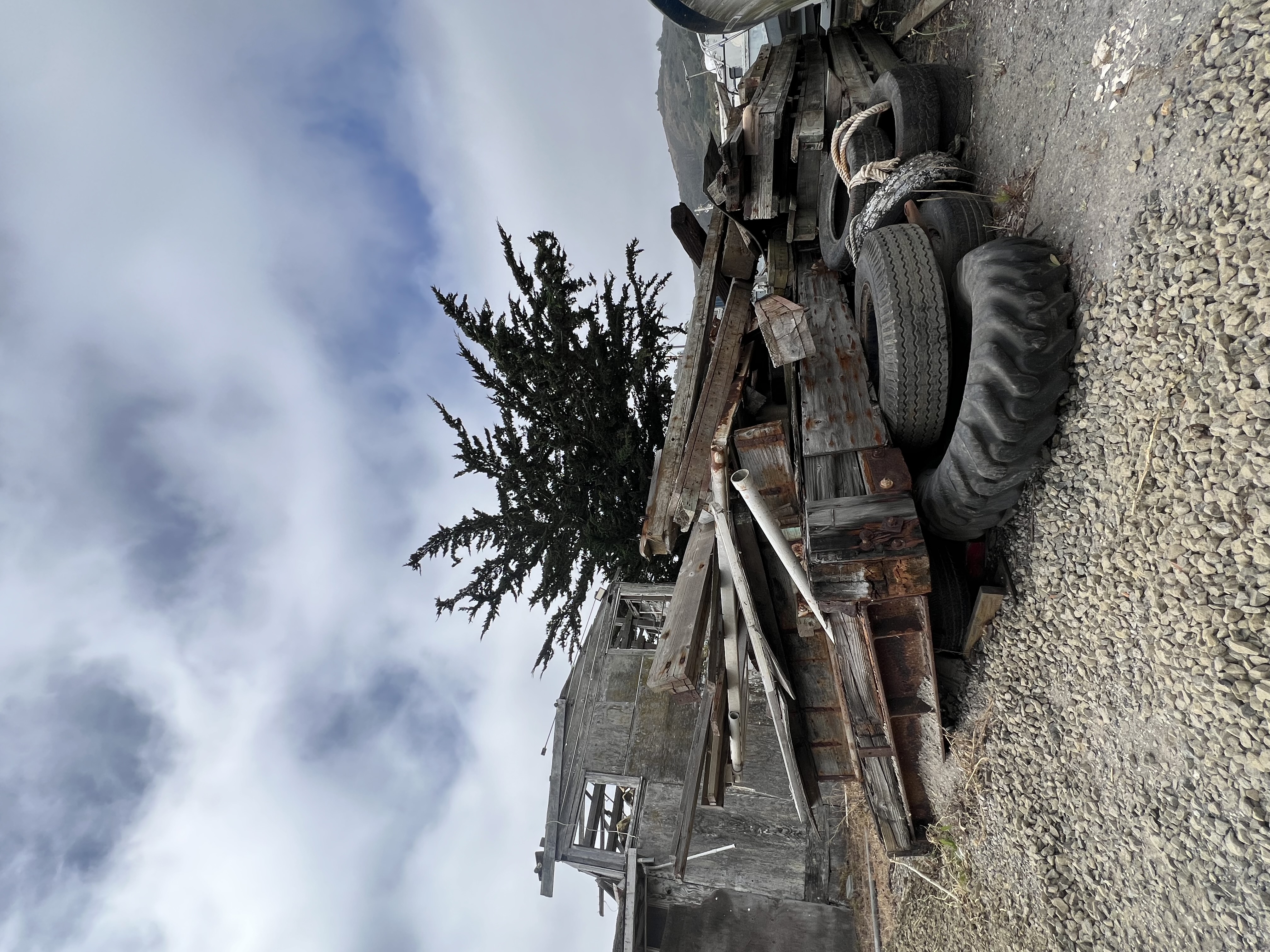 Weathered Marinship building, discarded tires and stacked timbers